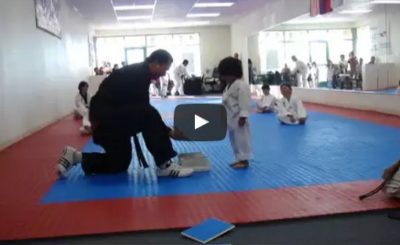 Little Boy Trying To Break Board In Taekwondo